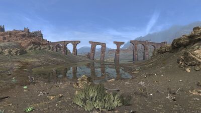 What was once a grand bridge to an island in the lake is now a toppling ruin leading to a dry hill.